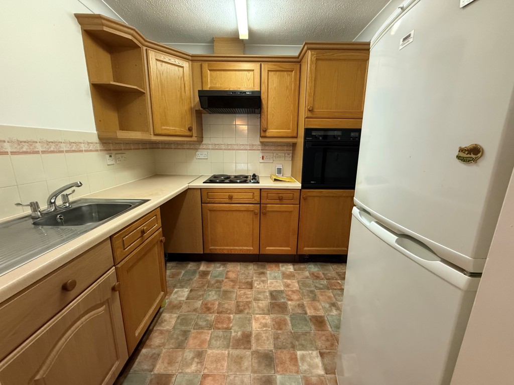 Lot: 73 - ONE-BEDROOM RETIREMENT FLAT - Tiled kitchen with wooden units and inbuilt hob and oven